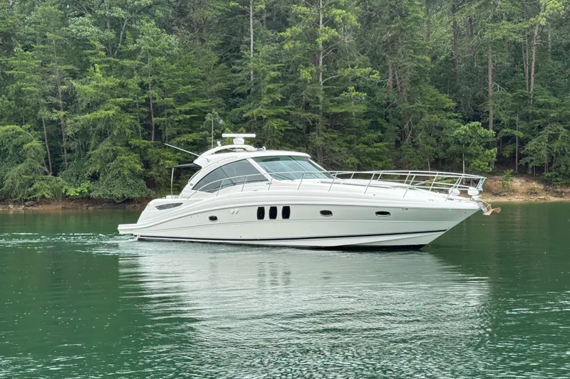 Slide: The Image of 2007 Sea Ray 48 Sundancer yacht cruising on a serene lake with lush forest backdrop. - 15