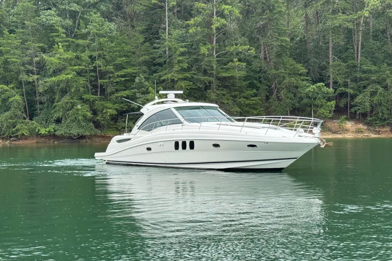 Slide: The Image of 2007 Sea Ray 48 Sundancer yacht cruising on a serene lake with forest backdrop. - 16