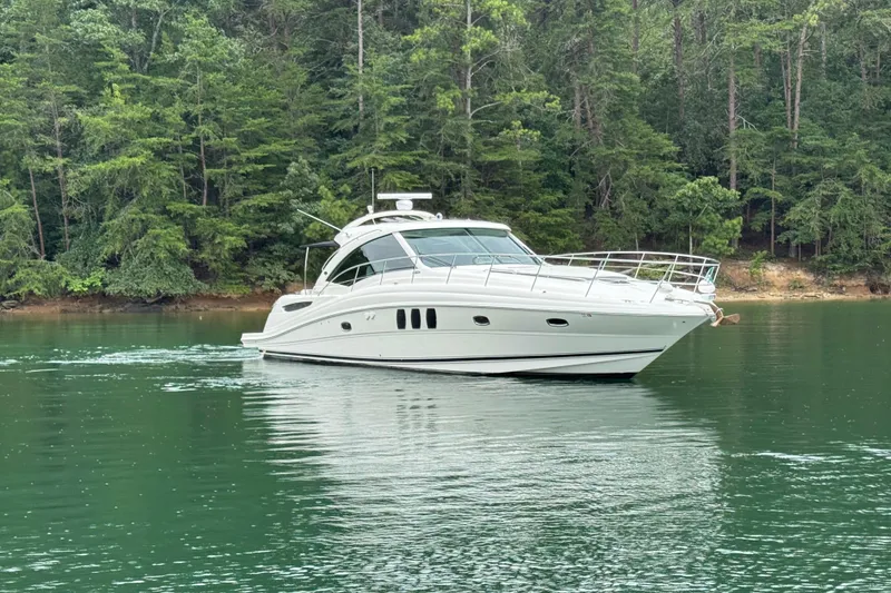 Slide: The Image of 2007 Sea Ray 48 Sundancer yacht cruising on a serene lake with lush forest backdrop. - 17