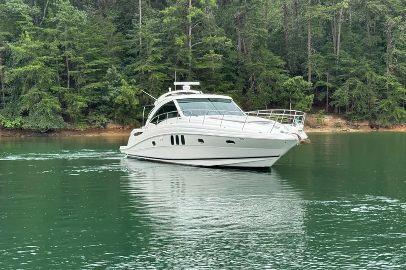 Slide: The Image of 2007 Sea Ray 48 Sundancer yacht cruising on a serene lake with lush forest backdrop. - 18