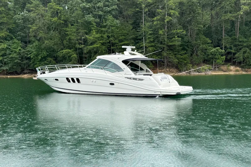 Slide: The Image of 2007 Sea Ray 48 Sundancer yacht cruising on a serene lake with lush forest backdrop. - 2