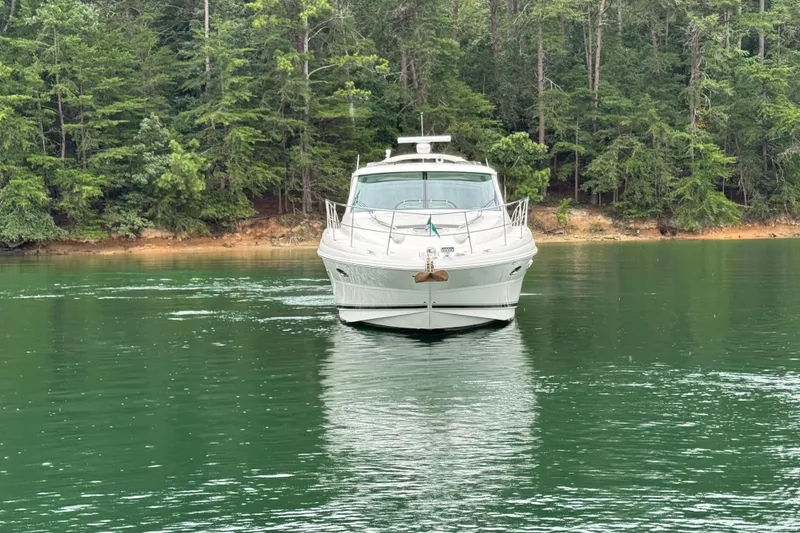 Slide: The Image of 2007 Sea Ray 48 Sundancer yacht on a serene lake with forest backdrop. - 22