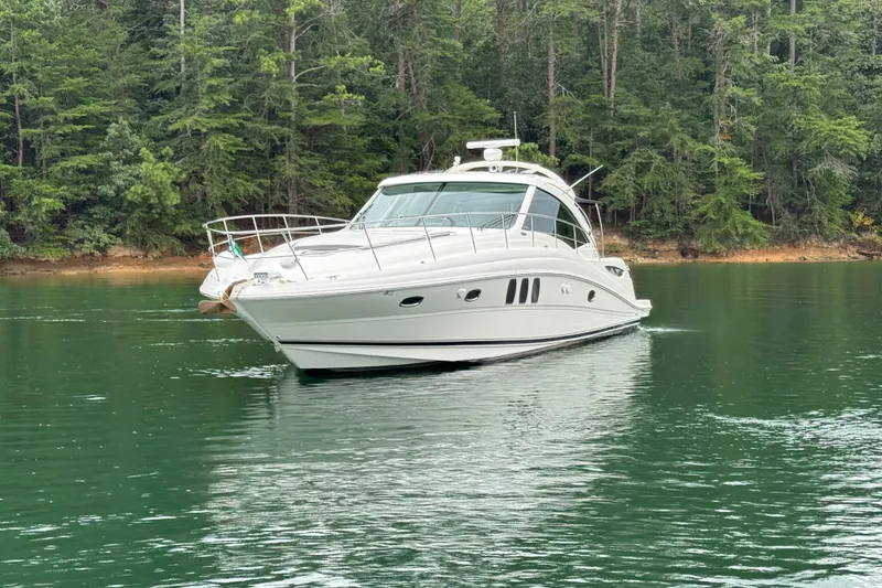 Slide: The Image of 2007 Sea Ray 48 Sundancer yacht on a serene lake with lush forest backdrop. - 25