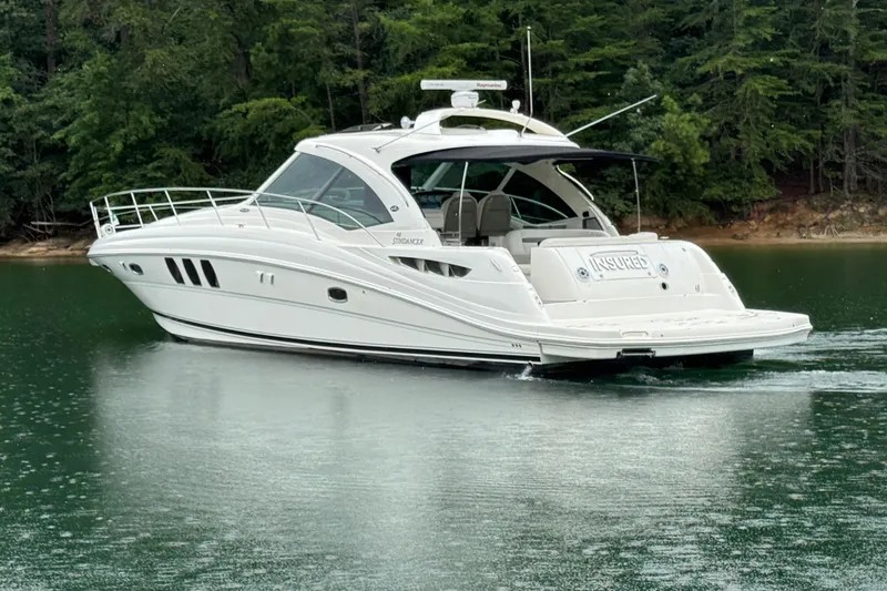 Slide: The Image of 2007 Sea Ray 48 Sundancer yacht cruising on a serene lake with lush forest backdrop. - 3