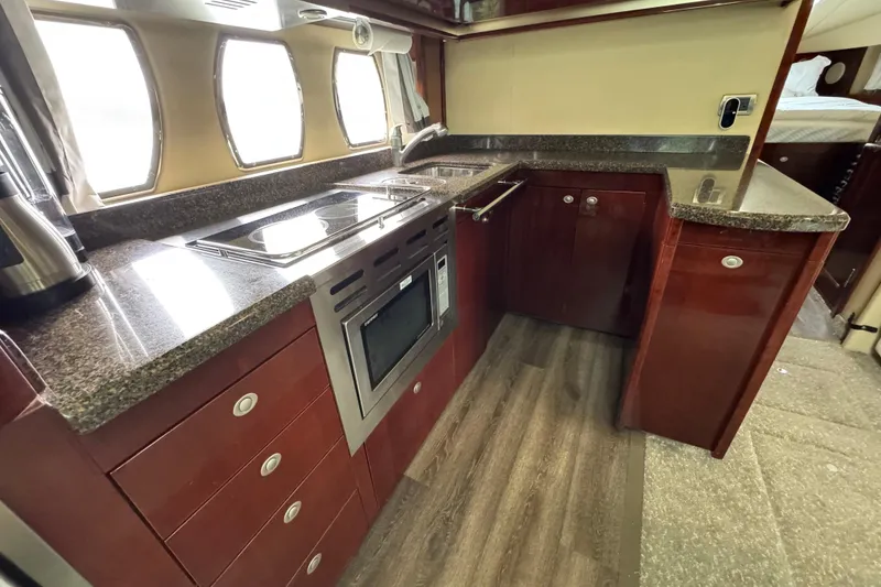 Slide: The Image of Luxurious 2007 Sea Ray 48 Sundancer yacht kitchen with modern appliances and elegant wood cabinetry. - 30