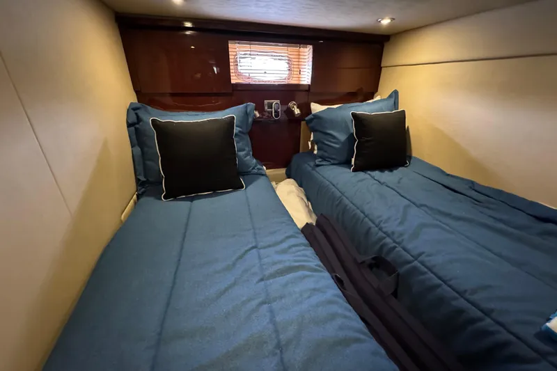 Slide: The Image of Twin beds in the 2007 Sea Ray 48 Sundancer cabin with blue bedding and pillows. - 32