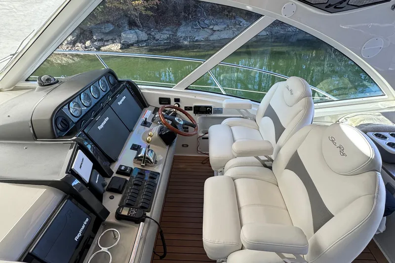 Slide: The Image of 2007 Sea Ray 48 Sundancer helm with dual seats, Raymarine electronics, and wood flooring. - 36