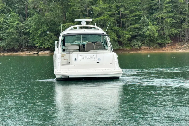 Slide: The Image of 2007 Sea Ray 48 Sundancer yacht cruising on a serene lake with lush forest backdrop. - 5