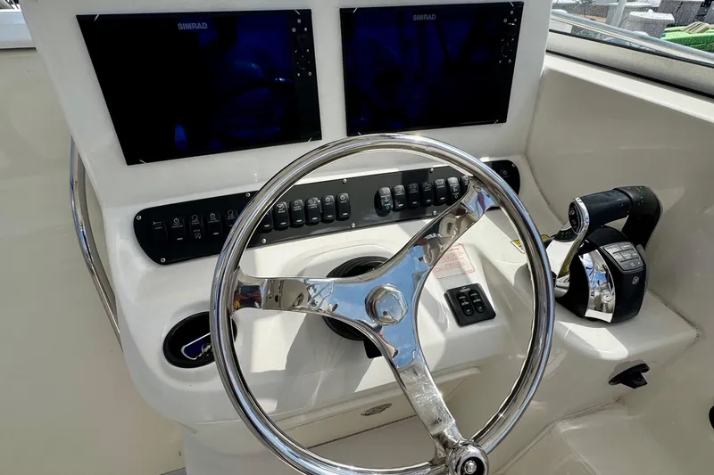 Slide: The Image of 2005 Boston Whaler 305 Conquest helm with dual Simrad displays and controls. - 13