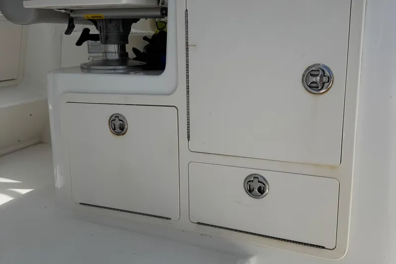 Slide: The Image of 2005 Boston Whaler 305 Conquest storage compartments with secure latches. - 25
