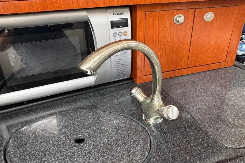 Slide: The Image of Kitchen area of a 2005 Boston Whaler 305 Conquest with faucet and microwave. - 36
