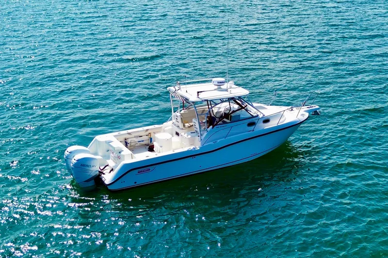 Slide: The Image of 2005 Boston Whaler 305 Conquest boat on clear blue water. - 5