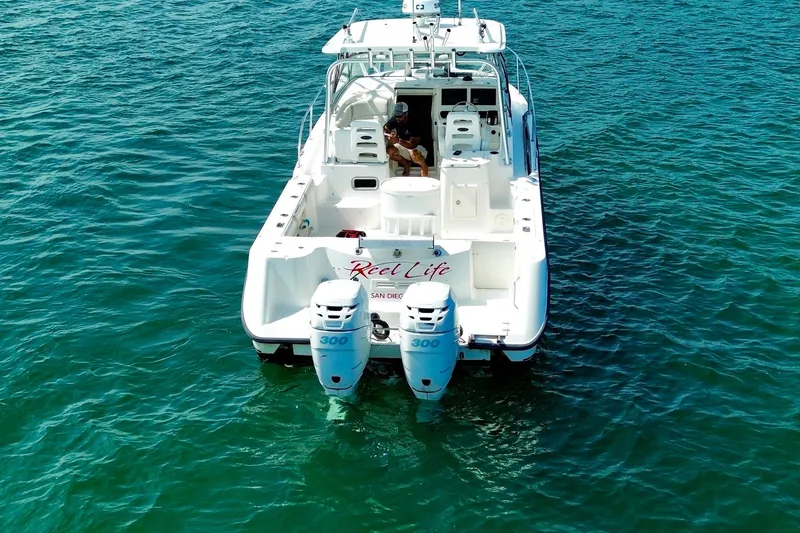 Slide: The Image of 2005 Boston Whaler 305 Conquest boat on clear blue water, rear view. - 9