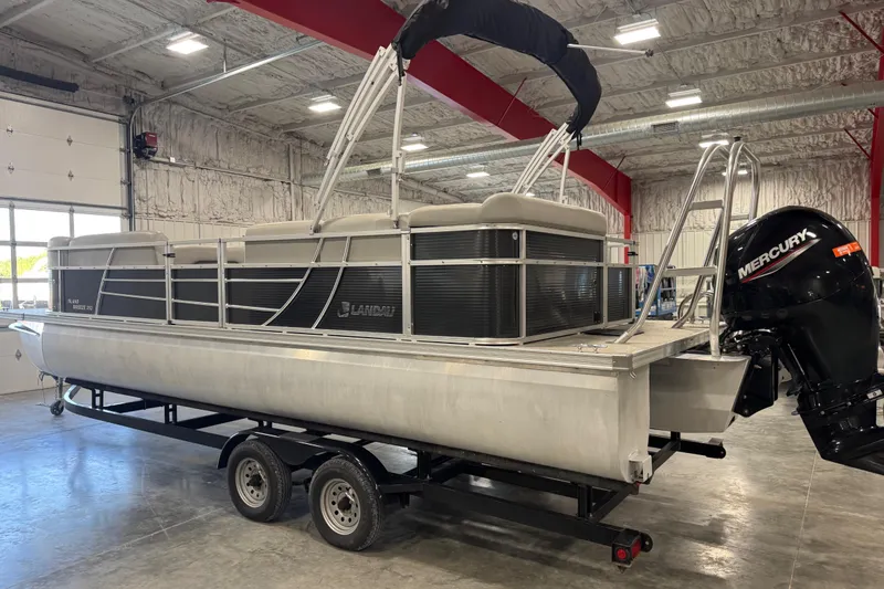 Slide: The Image of 2022 Landau Island Breeze 252 pontoon boat with Mercury engine in a warehouse setting. - 3
