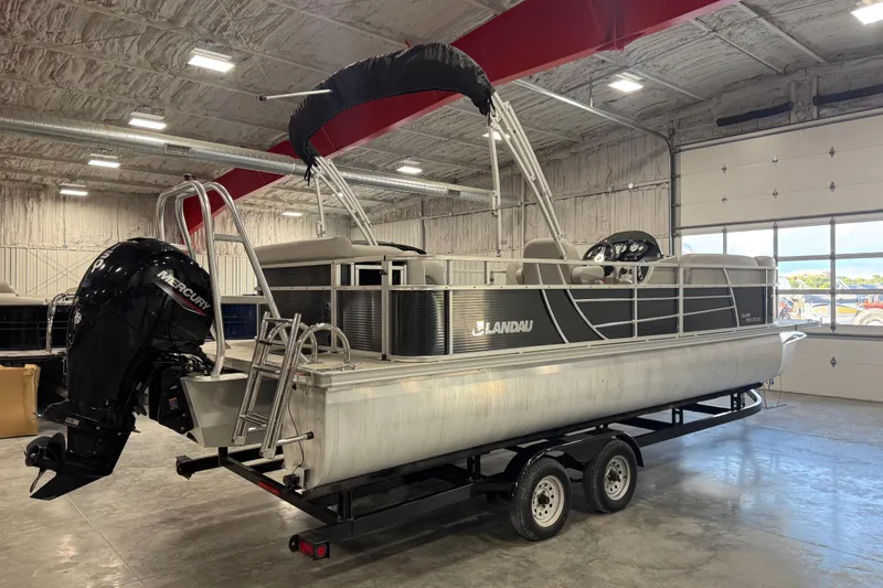 Slide: The Image of 2022 Landau Island Breeze 252 pontoon boat in a warehouse setting. - 4