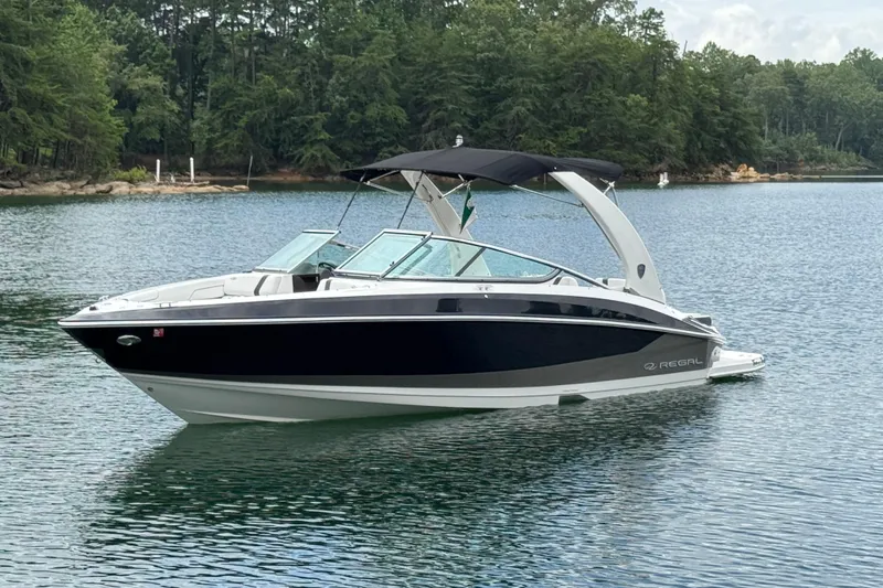 The Image of 2018 Regal 2500 Bowrider boat on a serene lake with lush green trees. - 0