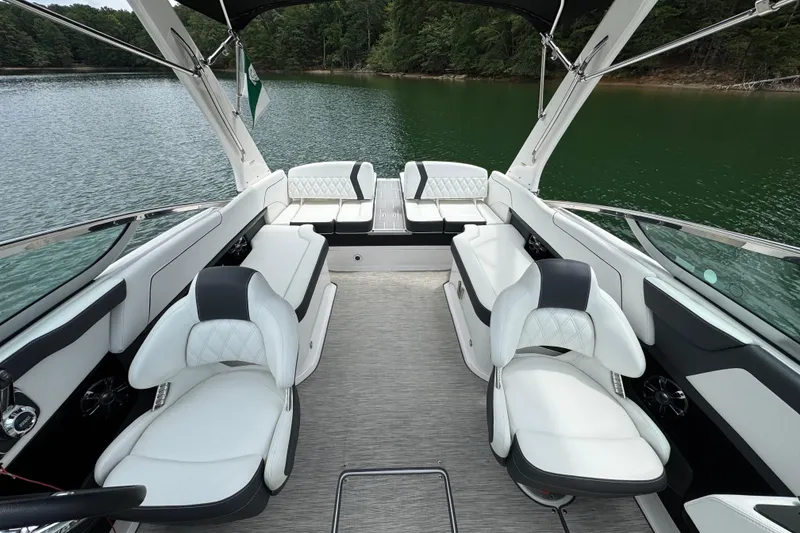 Slide: The Image of 2018 Regal 2500 Bowrider interior with luxurious white seating on a serene lake. - 11