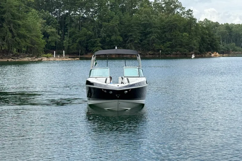 Slide: The Image of 2018 Regal 2500 Bowrider on a serene lake with forested shoreline. - 2