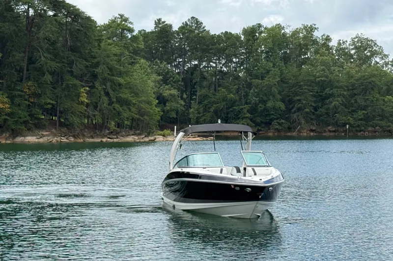 Slide: The Image of 2018 Regal 2500 Bowrider cruising on a serene lake with lush forest backdrop. - 3