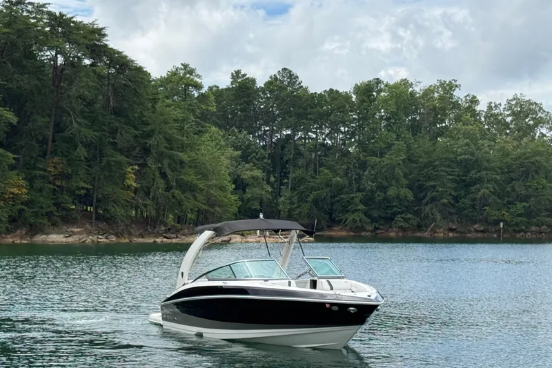 Slide: The Image of 2018 Regal 2500 Bowrider cruising on a serene lake with lush forest backdrop. - 4