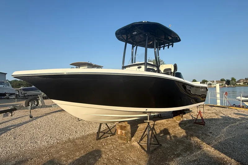 The Image of 2025 Tidewater 198 CC Adventure boat on stands, black hull, sunny day. - 1