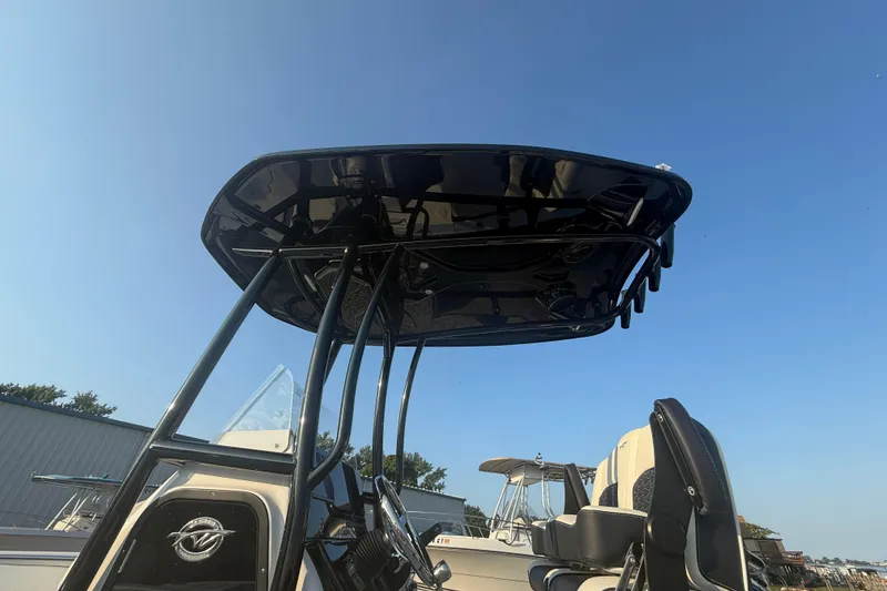 Slide: The Image of 2025 Tidewater 198 CC Adventure boat with T-top under clear blue sky. - 12