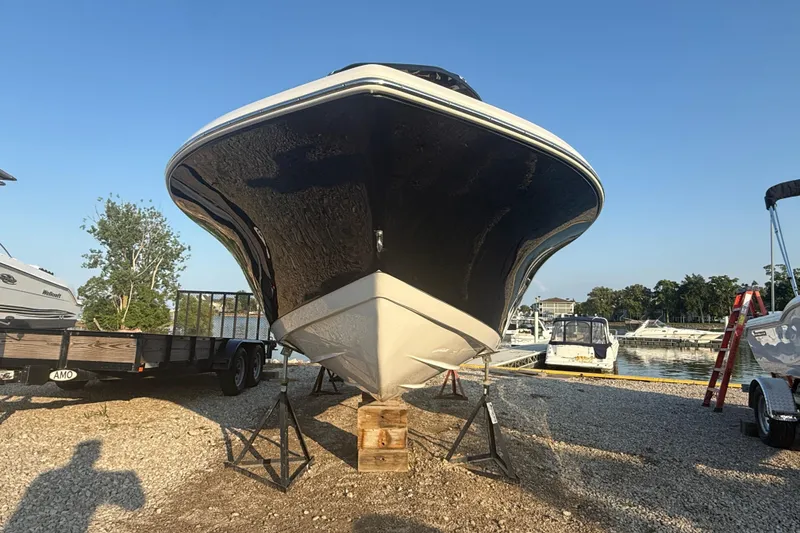 Slide: The Image of 2025 Tidewater 198 CC Adventure boat on stands at marina, clear sky background. - 13
