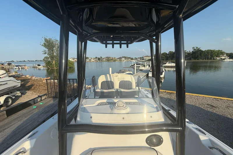 Slide: The Image of 2025 Tidewater 198 CC Adventure boat docked by a scenic waterfront. - 6