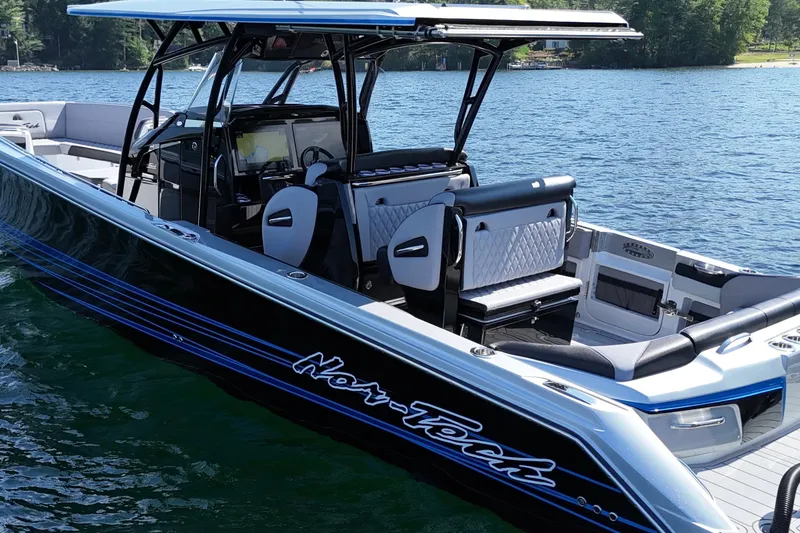 Slide: The Image of 2026 Nor-Tech 390 Sport Center Console boat on a serene lake. - 10