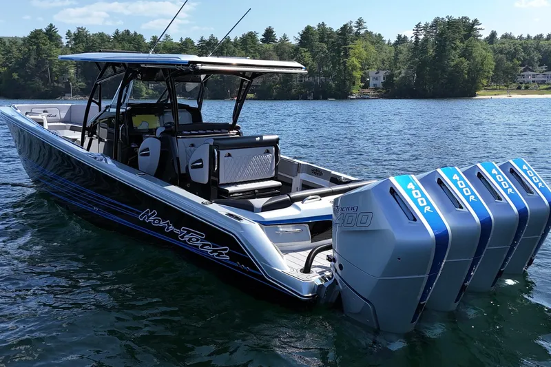 Slide: The Image of 2026 Nor-Tech 390 Sport Center Console boat with four powerful outboard engines on a lake. - 11