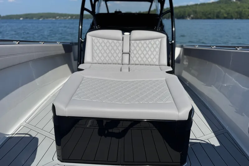 Slide: The Image of 2026 Nor-Tech 390 Sport Center Console with luxurious seating on a serene lake. - 17
