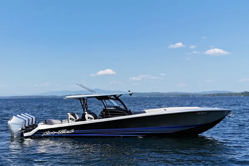 Slide: The Image of 2026 Nor-Tech 390 Sport Center Console boat on open water under clear blue sky. - 2