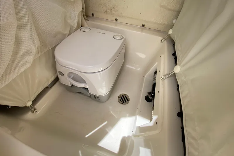 Slide: The Image of 2023 Key West 239 FS boat interior with portable toilet and storage area. - 103