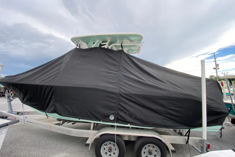 Slide: The Image of 2023 Key West 239 FS boat covered on trailer under cloudy sky. - 123