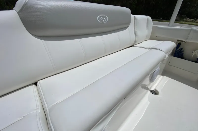Slide: The Image of 2023 Key West 239 FS boat with white cushioned seating and KW logo. - 21