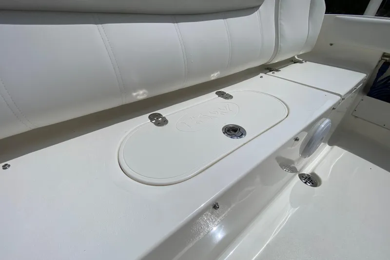 Slide: The Image of 2023 Key West 239 FS boat interior with white cushioned seating and storage compartment. - 26