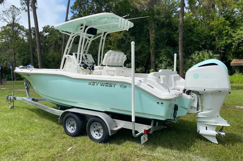 Slide: The Image of 2023 Key West 239 FS boat on trailer, featuring Yamaha engine, parked on grass. - 3