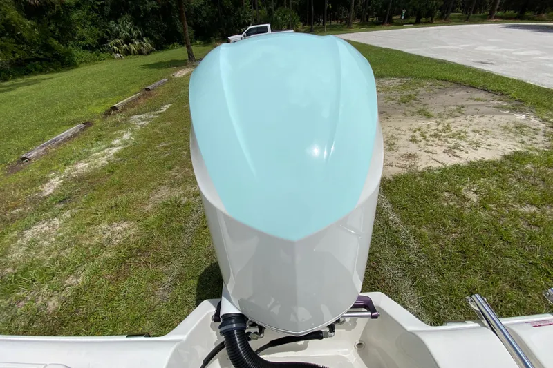 Slide: The Image of 2023 Key West 239 FS boat engine, light blue cover, parked on grassy area. - 38