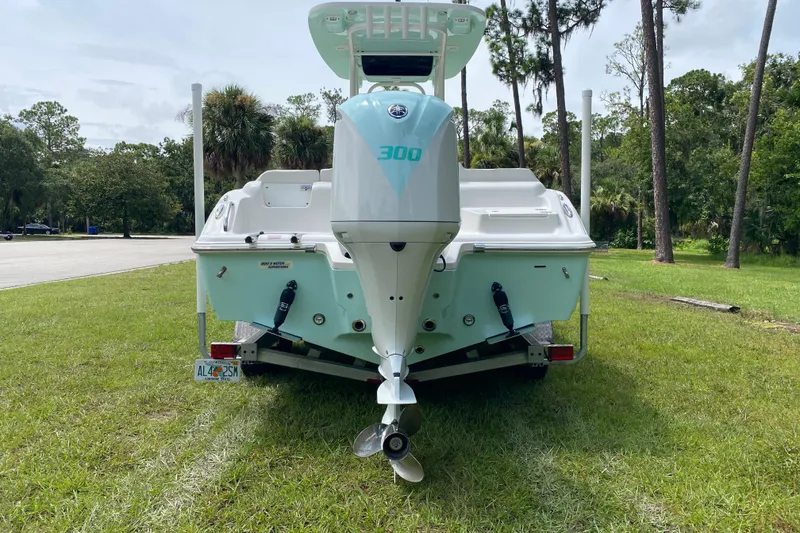 Slide: The Image of 2023 Key West 239 FS boat with powerful outboard motor, parked on grass. - 4