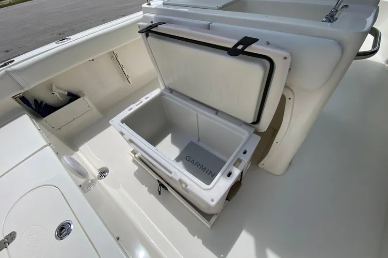Slide: The Image of 2023 Key West 239 FS boat interior with open storage compartment and Garmin cooler. - 46