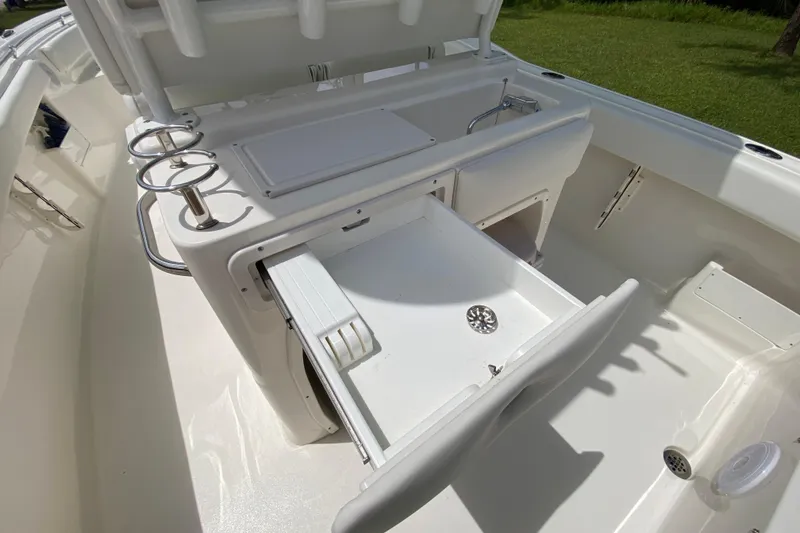 Slide: The Image of 2023 Key West 239 FS boat interior with open storage compartments and cup holders. - 51