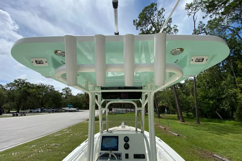 Slide: The Image of 2023 Key West 239 FS boat with T-top, console, and lush green surroundings. - 53