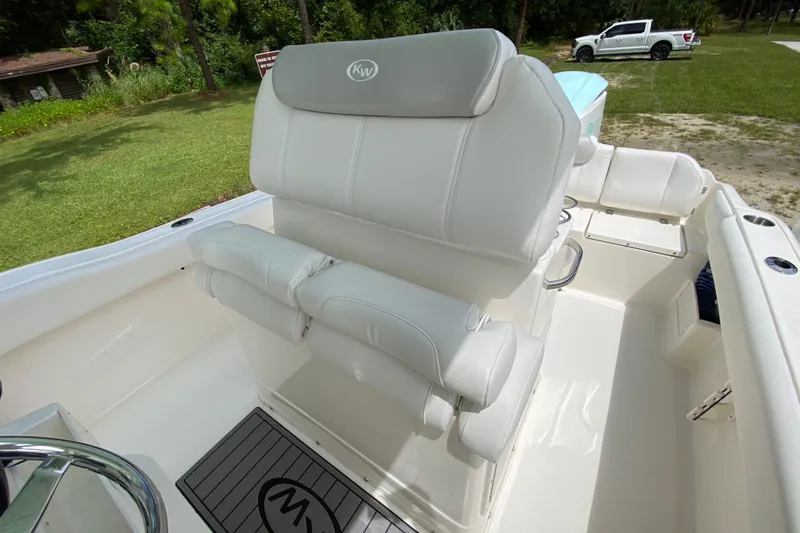 Slide: The Image of 2023 Key West 239 FS boat interior with white seating and steering wheel. - 56