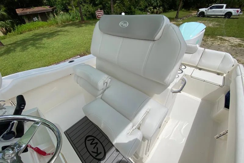 Slide: The Image of 2023 Key West 239 FS boat interior with white seating and steering wheel. - 57