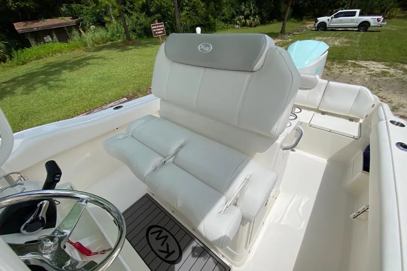 Slide: The Image of 2023 Key West 239 FS boat interior with white seating and steering wheel. - 58