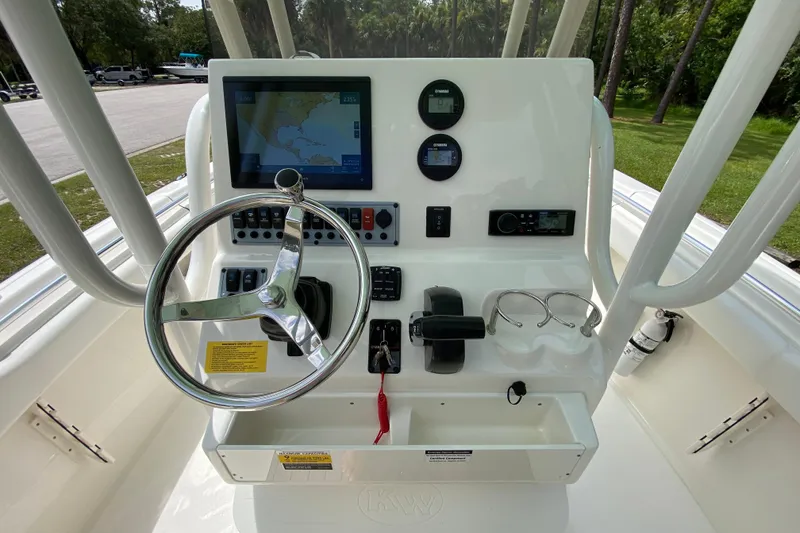 Slide: The Image of 2023 Key West 239 FS boat dashboard with steering wheel, controls, and navigation display. - 59