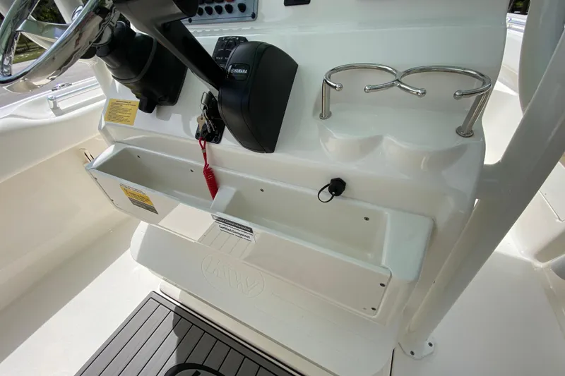 Slide: The Image of 2023 Key West 239 FS boat console with steering wheel, controls, and cup holders. - 68