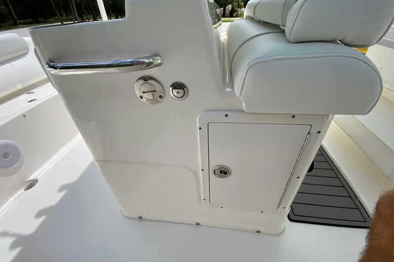 Slide: The Image of 2023 Key West 239 FS boat interior, featuring white seating and storage compartment. - 71