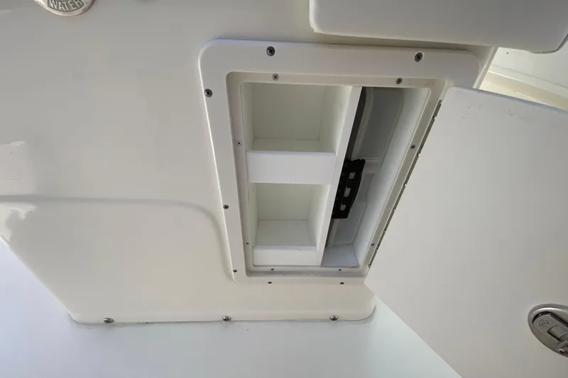 Slide: The Image of 2023 Key West 239 FS boat storage compartment with open door, showcasing interior space. - 72