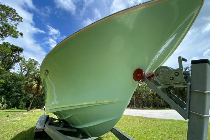 Slide: The Image of 2023 Key West 239 FS boat on trailer, green hull, outdoor setting. - 8